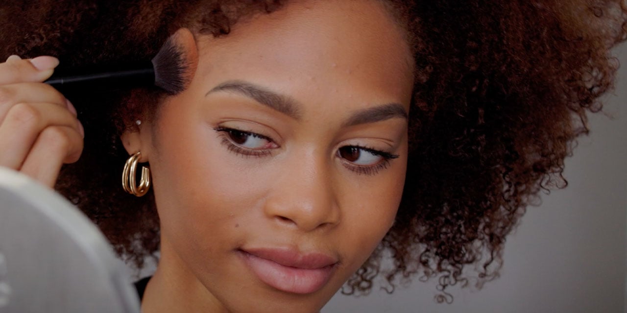 Model applying bronzer for all-over warmth